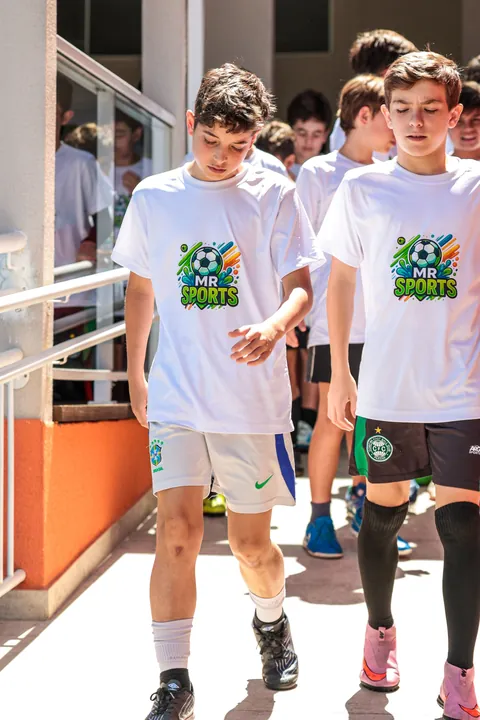 Dois meninos de camiseta branca da MR Sports caminham no corredor